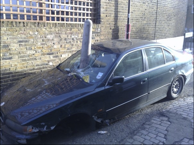 Screen-shot-2011-07-21-at-copy.jpg - When you encounter a car so completely FUBAR that it has crash-landed *on* a six-foot tall bollard, you're really taking the proverbial when you put a parking ticket on it.